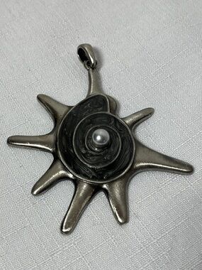 Vintage-style sun pendant, spiral shell design & a central pearl. Silver tone.